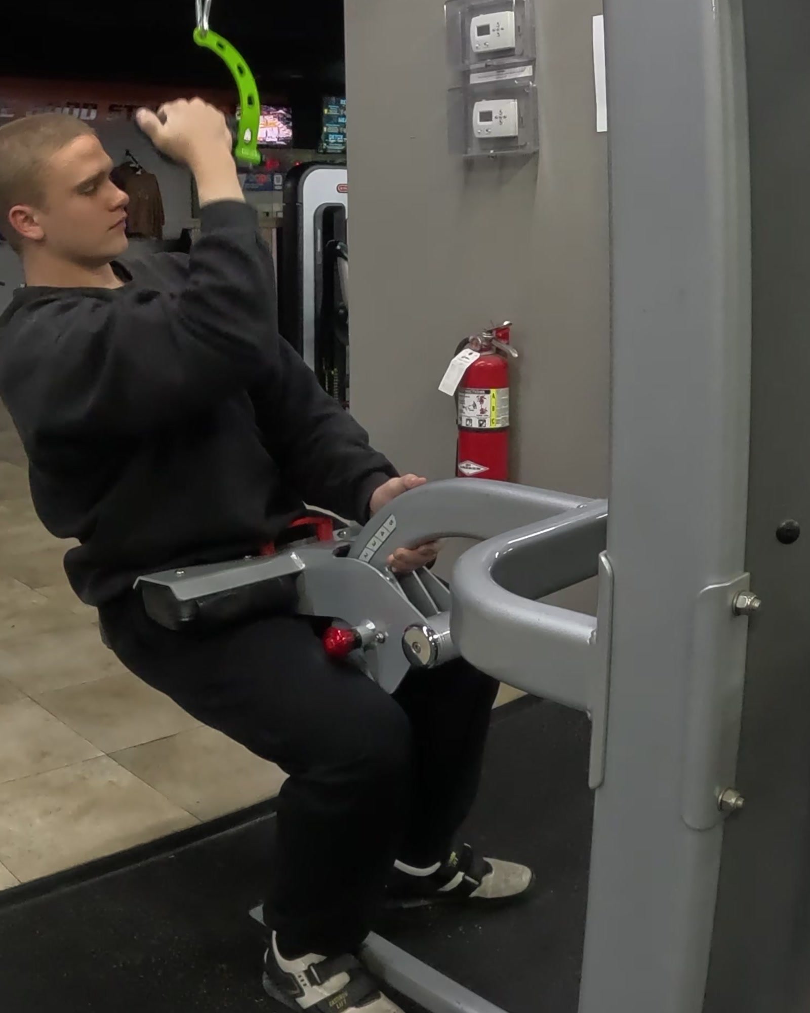 Markus performing a single-arm lat pulldown in the gym.